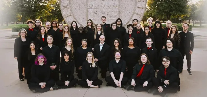 Fotografía de grupo del coro de Texas Tech, vestido de negro, en una escalinata.