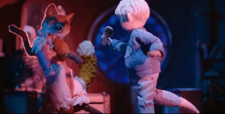 Fotograma de un cortometraje de animación en plastilina: un personaje rosa y otro azul frente a frente bajo una luz roja.